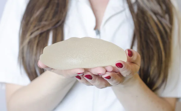 Silicone breast implants. Nurse holding implants. Doctor holding implants. Plastic surgery — Stock Photo, Image