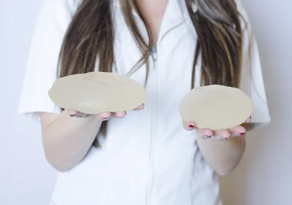 Silicone breast implants. Nurse holding implants. Doctor holding implants. Plastic surgery — Stock Photo, Image