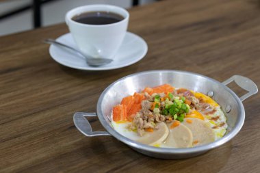 Kahvaltıda yakın plan yumurta, domuz kıyması, yengeç çubuğu ve domuz sosisi ve kahveyle servis edilir.