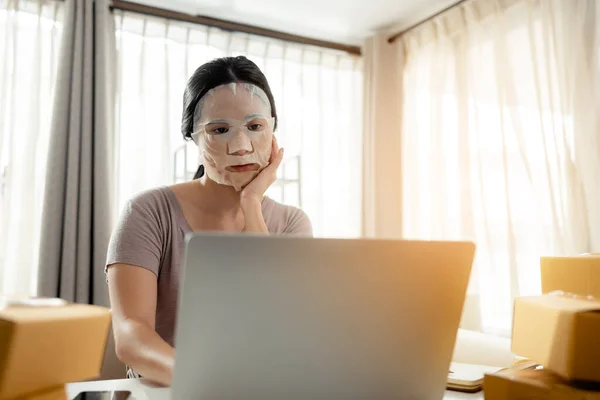 Kadınlar Evde Dizüstü Bilgisayarla Çalışırken Yüz Bakımı Maskesi Takıyorlar — Stok fotoğraf