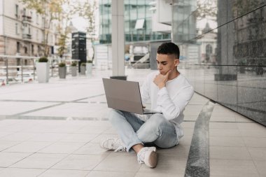 Bilgisayarla uzaktan çalışan yakışıklı bir serbest yazar. Bilişim parkında işini uzaktan yapan mutlu bir adam..