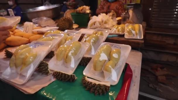 Bangkok 'taki yerel sokak gıda pazarı. Tezgahta egzotik meyveler var. Mango ve Durian. Koruyucu tıbbi maskeli satıcılar var. Koronavirüs sırasında Tayland 'da yaşam, covid 19. — Stok video