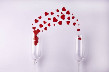 Beyaz arka planda kırmızı kalpli iki bardak. Sevgililer Günü, aşk konsepti. Düz konum, üst görünüm, kopyalama alanı.