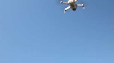 Mavi gökyüzü arka planında dijital kameralı beyaz dron