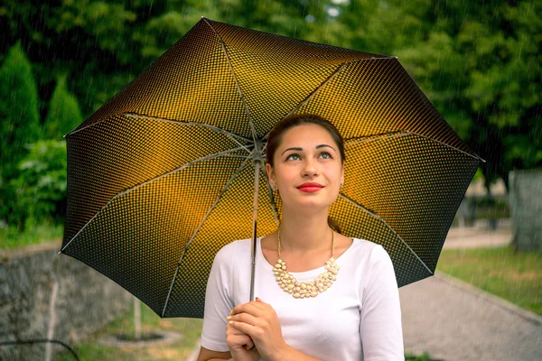 Девушка под зонтиком, наблюдающая за небом — стоковое фото