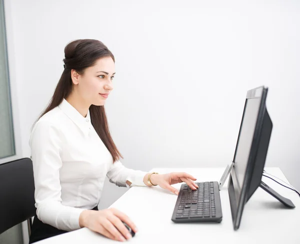 Joven mujer de negocios que trabaja con una computadora en la oficina —  Fotos de Stock