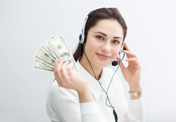 Usměvavá podnikatelka ve sluchátkách drží v ruce bankovky Stock Fotografie