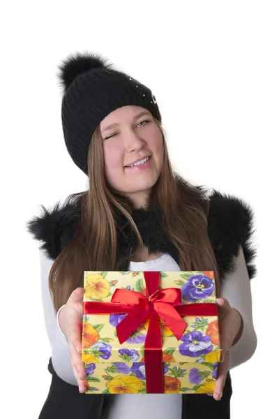 Mädchen mit Hut zwinkert mit einem Geschenk — Stockfoto