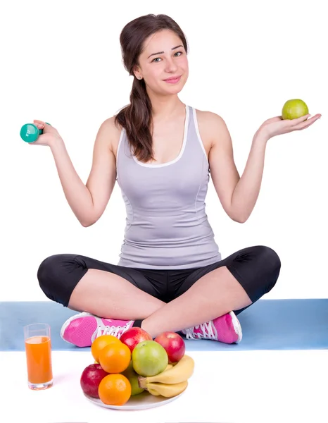 Mädchen auf dem Teppich mit Apfel und Hantel — Stockfoto