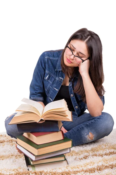 Girl student sitting with a pile of books — Stockfoto