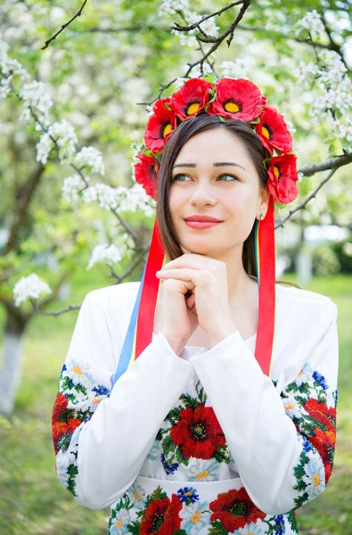 Chica de ensueño en ropa nacional en un jardín floreciente — Foto de Stock