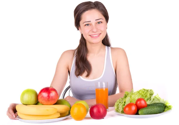 Красивая девушка с фруктами и овощами на столе — стоковое фото
