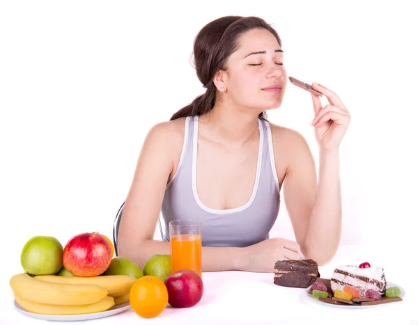 Menina escolhe entre doces e frutas — Fotografia de Stock