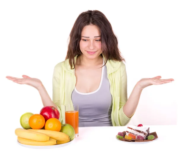 Menina escolhe entre frutas e doces — Fotografia de Stock