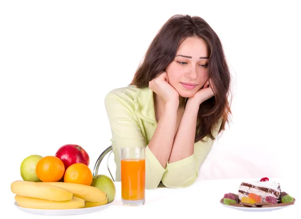 Mädchen wählt zwischen Obst und Süßigkeiten — Stockfoto