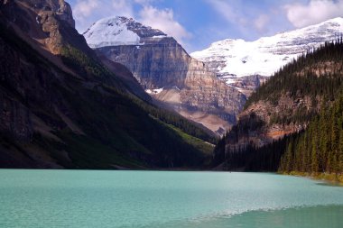 Kanada 'daki Banff Ulusal Parkı' nda Louise Gölü 'nün turkuaz suyunun üzerindeki görkemli buzullar.