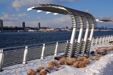 Riverside Parkı 'nda karlı nehrin manzarasının keyfini çıkarmak için muhteşem bir bank.