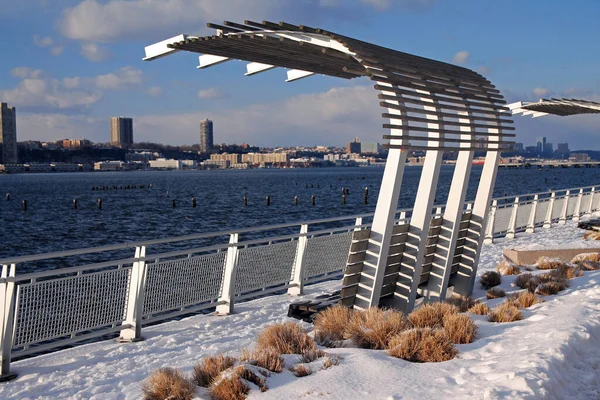 Riverside Parkı 'nda karlı nehrin manzarasının keyfini çıkarmak için muhteşem bir bank.