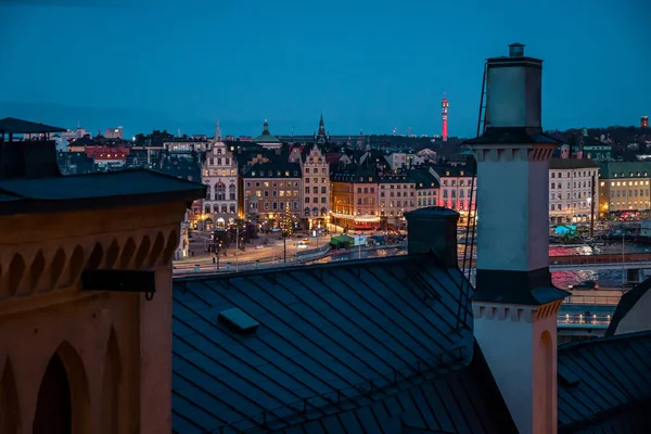 Kilátás nyílik az esti európai városra. Kilátás skyline Stockholm, Svédország felülről. Rengeteg színes épület, sok fekete ón fém tető.. — Stock Fotó