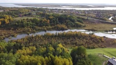 Ormandaki tepede bir köy, İHA saldırısı. Bardan tipik ahşap evler. Sıcak güneşli bir gün, yaz manzarası. Pürüzsüz yeşil çimenler, gerçek doğa