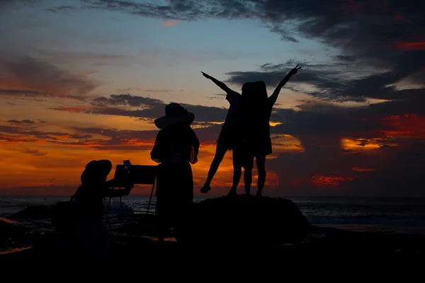 Silhouette, Mädchen schießen Foto für ihre Freunde. — Stockfoto