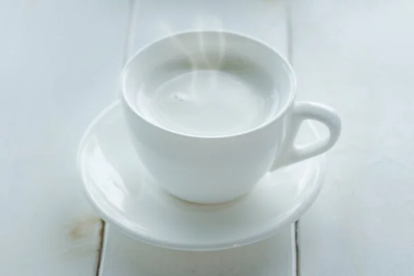 Горячее молоко на белом столе — стоковое фото