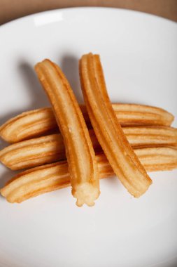 Beyaz arka planda çeşitli churro tabakları. Dikey resim.