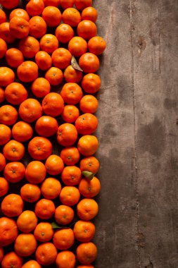 Tahta arka planda taze olgun mandalinalar. Dikey resim