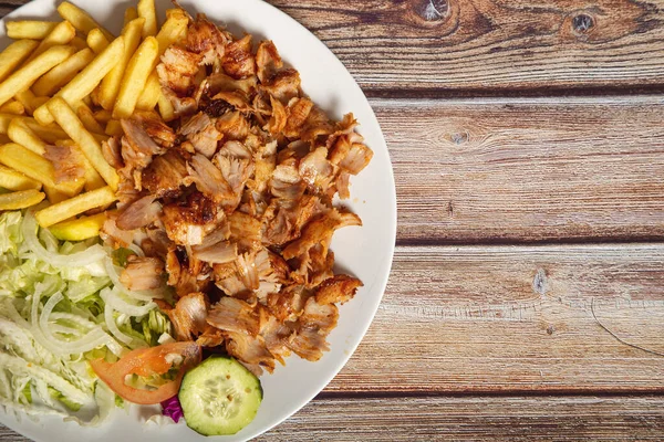 Patates kızartması ve ahşap arka planda salatalı tavuk çevirici. Mesaj için yer var.