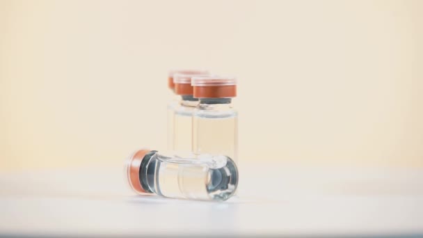 Uzavřete Injekční Lahvičky Vakcínou Bílém Stole Žlutém Pozadí Medicína — Stock video