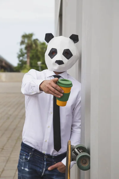 Businessman with panda bear mask drinking coffee. Selective focus