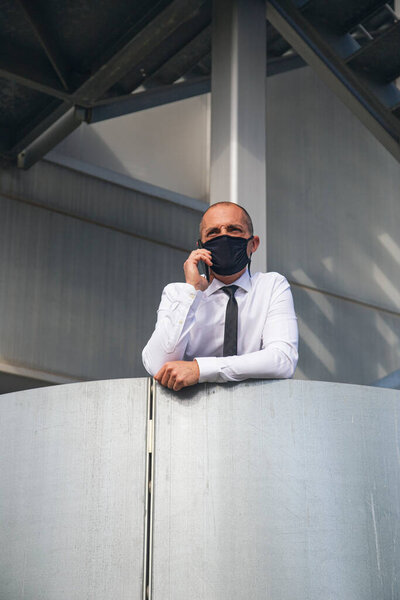 Businessman talking on the phone with face mask