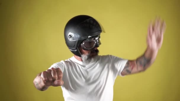 Homem Barbudo Com Capacete Simulando Dirigir Uma Motocicleta Fundo Amarelo — Vídeo de Stock