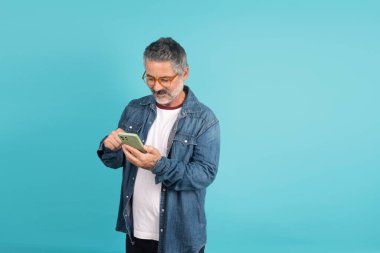 Akıllı telefon tutan adam, aşağıya bakıyor ve ekranla etkileşime geçiyor.