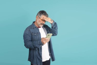 Kafasına telefonu dayamış, stresli ve sıkıntılı bir adam.