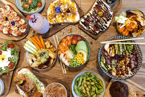 Masada canlı dürtme kaseleri, avokado tostları ve meyve püresi var.