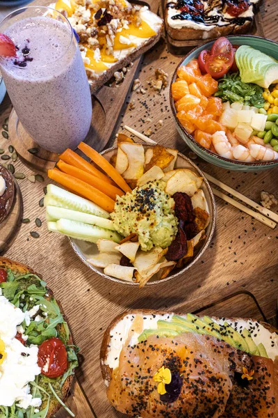 Poke kaseli lezzetli yemek, avokado tostu ve ahşap bir masada smoothie.