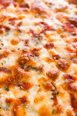 Eritilmiş mozzarella peyniri ve klasik İtalyan pizza yüzeyini kaplayan domates sosu.