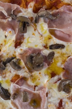 Jambonlu pizza, taze mantar ve mozzarella peyniri servis için hazır.