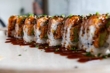 Taze taze soğan ve aromalı soslu gevrek dolgulu suşi ruloları.