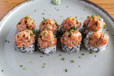 Baharatlı somon börekleri, üzerinde pirzola ve susam tohumları var.