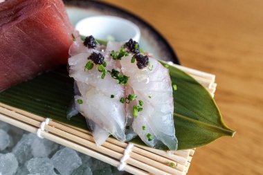 Çiğ ton balıklı taze sashimi tabağı ve havyarlı ezilmiş buzda servis edilen beyaz balık.