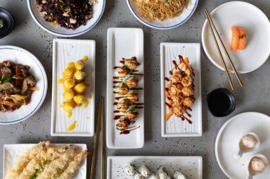 Farklı suşi ruloları, erişte, pilav, tempura ve biftek karışımı.