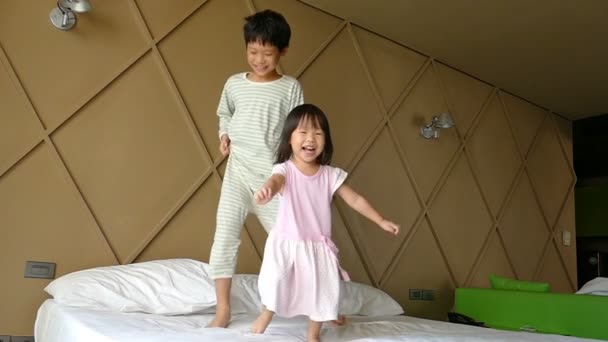 Діти стрибають на ліжку — стокове відео