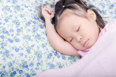 Kız yatakta uyuyor.