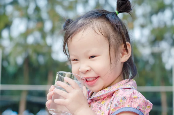 Niña sonríe después de beber agua de vidrio —  Fotos de Stock