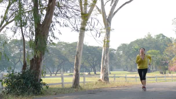 Yorgun kadın parkta koşu sırasında dinlenme — Stok video