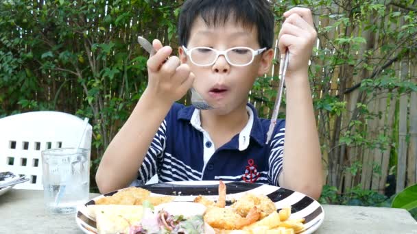 Chłopiec jeść obiad w restauracji — Wideo stockowe