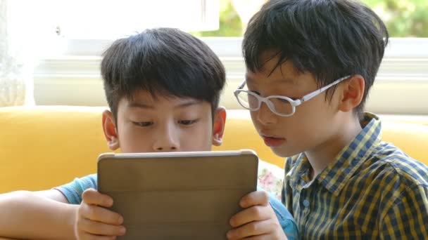 Boys playing games on a touchscreen tablet — Stock Video