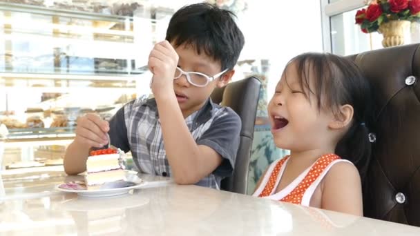 Hermanos comiendo pastel juntos — Vídeo de stock